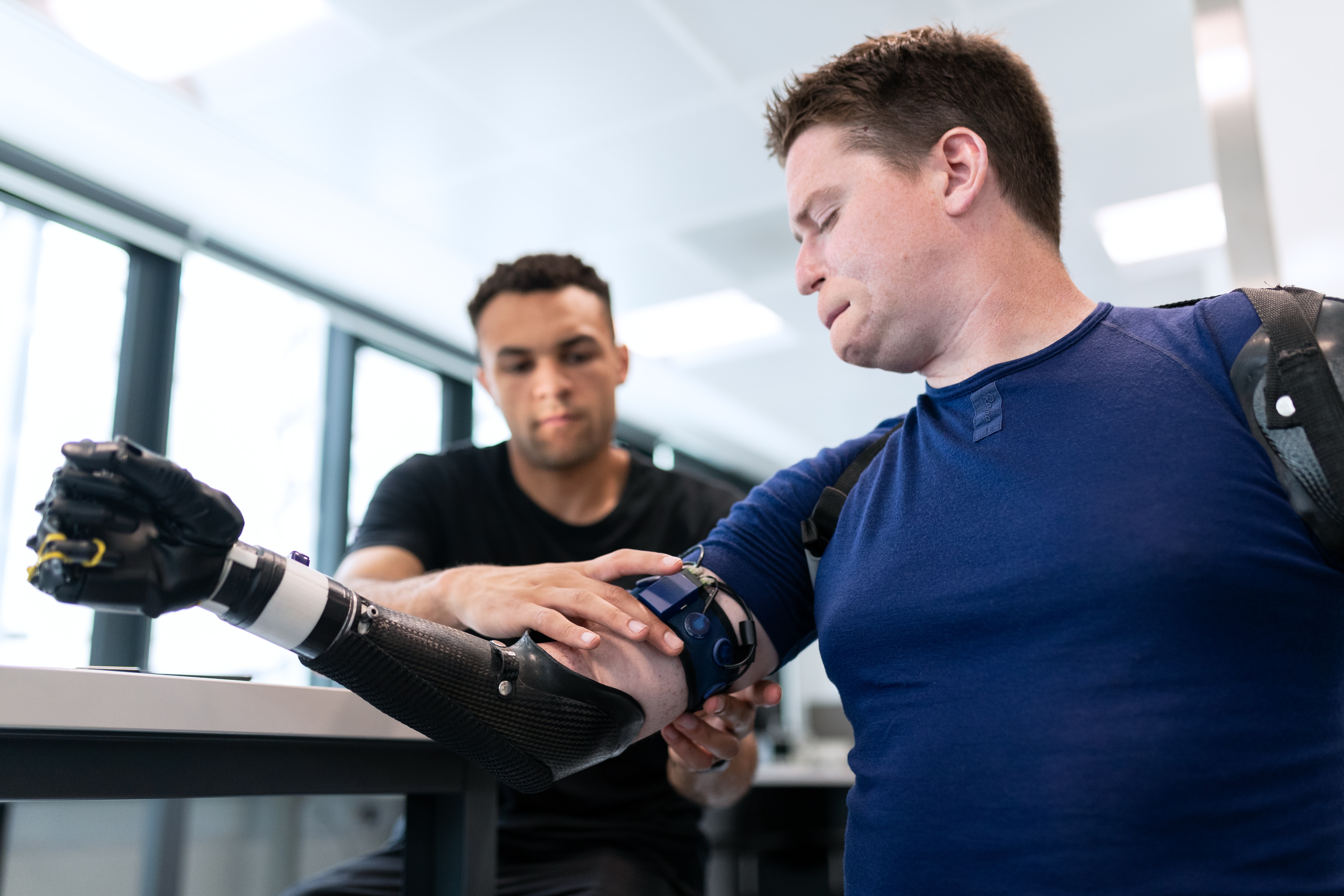 amputee getting help with a prosthetic arm